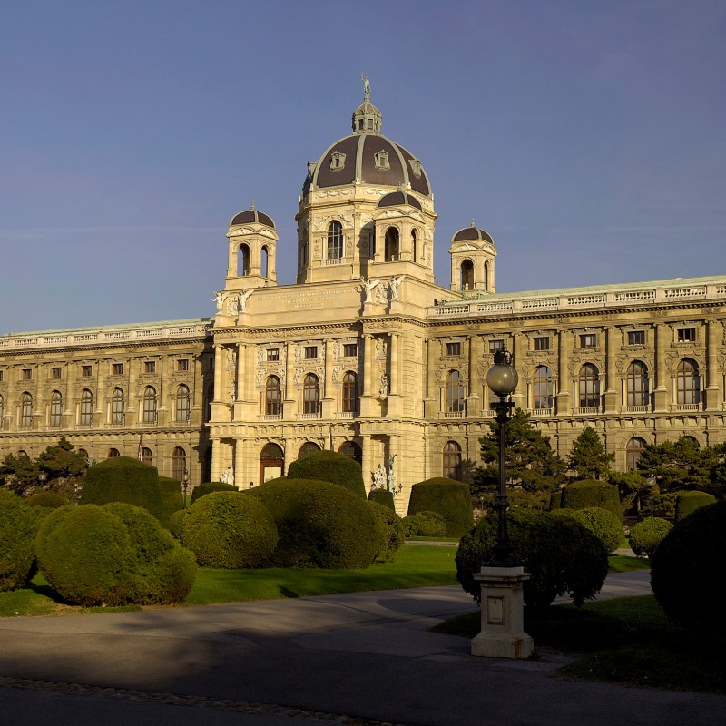 Frontal view of the Natural History Museum Vienna with a prominent dome, symmetrical facade, and manicured bushes
                                 in the foreground. (AI-generated alt-text, generated with GPT-4.1-mini)
