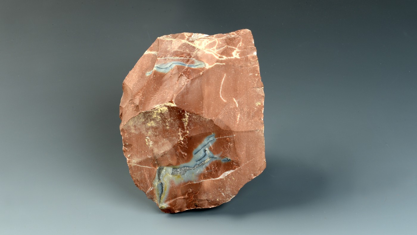 Large, irregularly shaped piece of chert with predominantly brown color and some light and dark gray inclusions.
                                 (AI-generated alt-text, generated with GPT-4.1-mini)