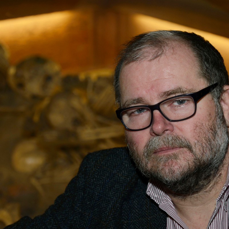 Man with glasses and beard, serious expression, wearing jacket and shirt, upper body view in front of blurred background.
                                 (AI-generated alt-text, generated with GPT-4.1-mini)