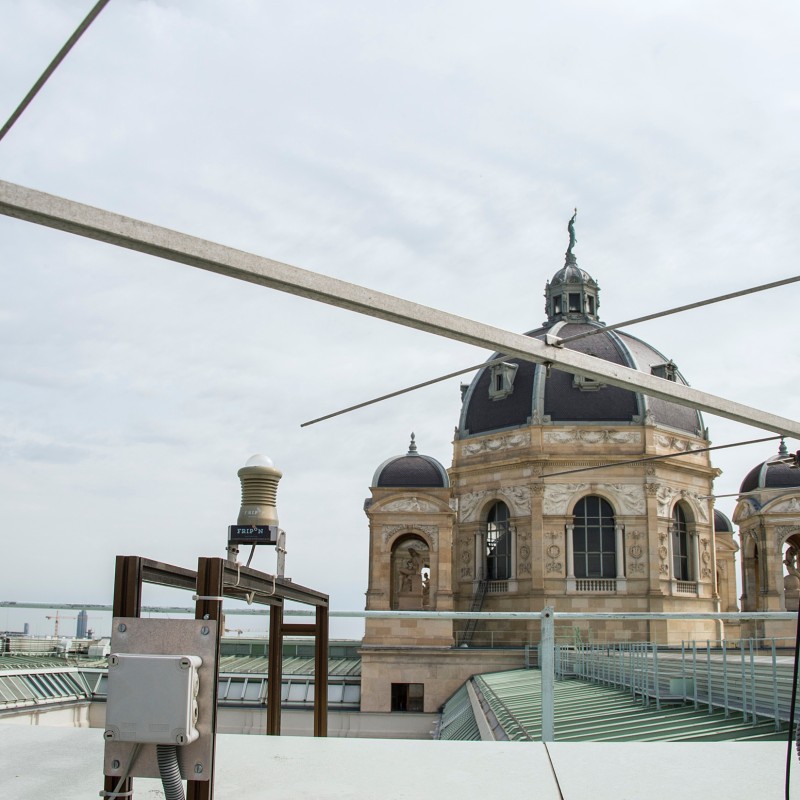 Metal
                                 antenna structure on a rooftop, with the distinctive dome of the Natural History Museum Vienna in the background. (AI-generated
                                 alt-text, generated with GPT-4.1-mini)