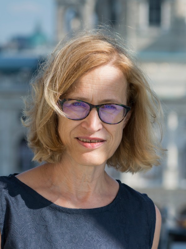 Frau
                                 mit schulterlangem blondem Haar, Brille und ärmellosem dunkelblauem Oberteil; neutraler Gesichtsausdruck, Hintergrund unscharf.
                                 (KI-generierter Alt-Text, erstellt mit GPT-4.1-mini)