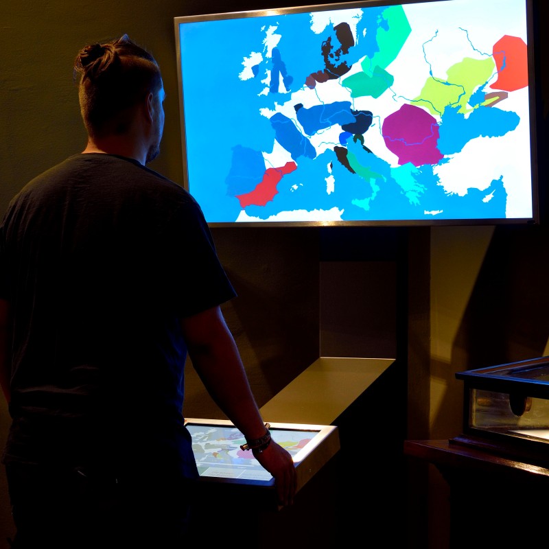 Person
                                 von hinten vor einem beleuchteten Bildschirm mit farbigen Gebietsmarkierungen Europas. (KI-generierter Alt-Text, erstellt
                                 mit GPT-4.1-mini)