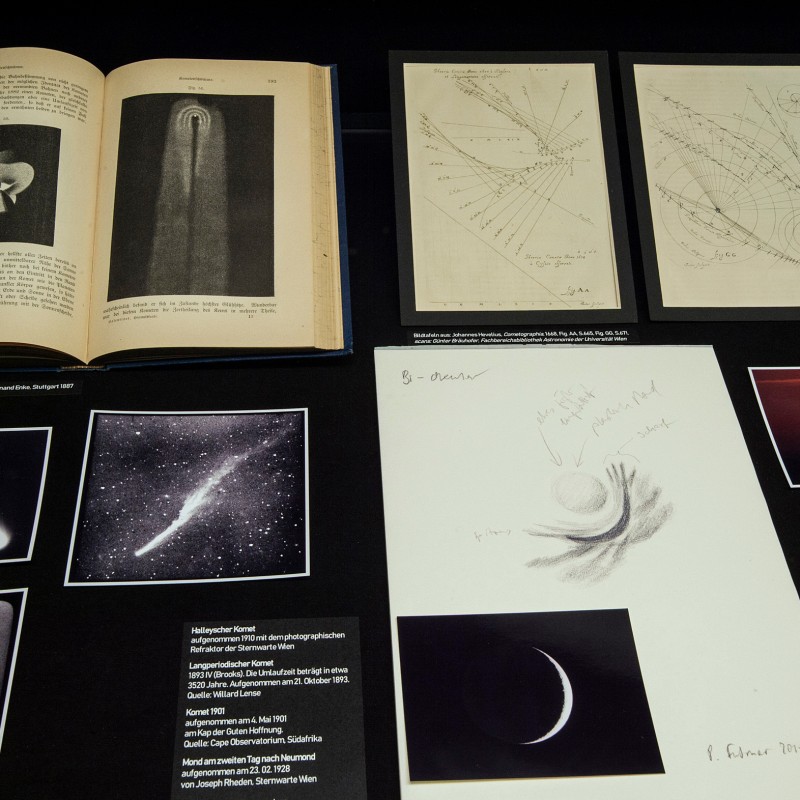 Open books and loose pages with scientific drawings and photographs of comets and celestial bodies laid out side
                                 by side. Some captions are legible. (AI-generated alt-text, generated with GPT-4.1-mini)
