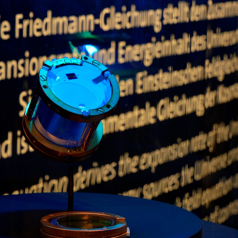 Kristall
                                 aus Calciumwolframat, das Kernstück des CRESST-Detektors, montiert auf einem Stativ vor text-hintergrund (KI-generierter Alt-Text,
                                 erstellt mit GPT-4.1-mini)