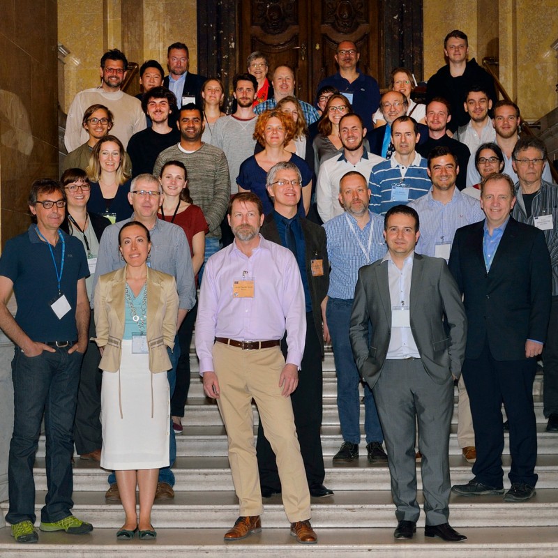 Group of people standing on a marble staircase in front of a historic building. Two roll-ups with the EURO-CARES
                                 logo and text flank the group. (AI-generated alt-text, generated with GPT-4.1-mini)