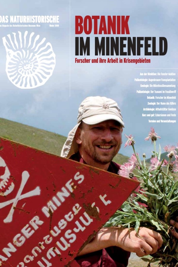 Lächelnder Mann mit rotem Basecap hält mit beiden Händen eine distelartige Pflanze, im Hintergrund bewölkter Himmel
                                 und ein rotes Warnschild mit weißer Aufschrift. (KI-generierter Alt-Text, erstellt mit GPT-4.1-mini)